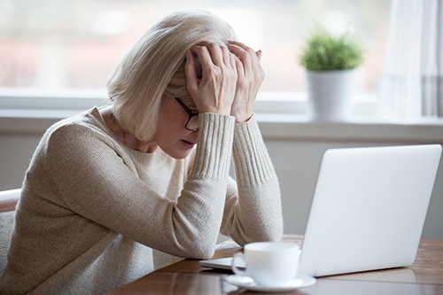 Upset and frustrated woman in front of a laptop